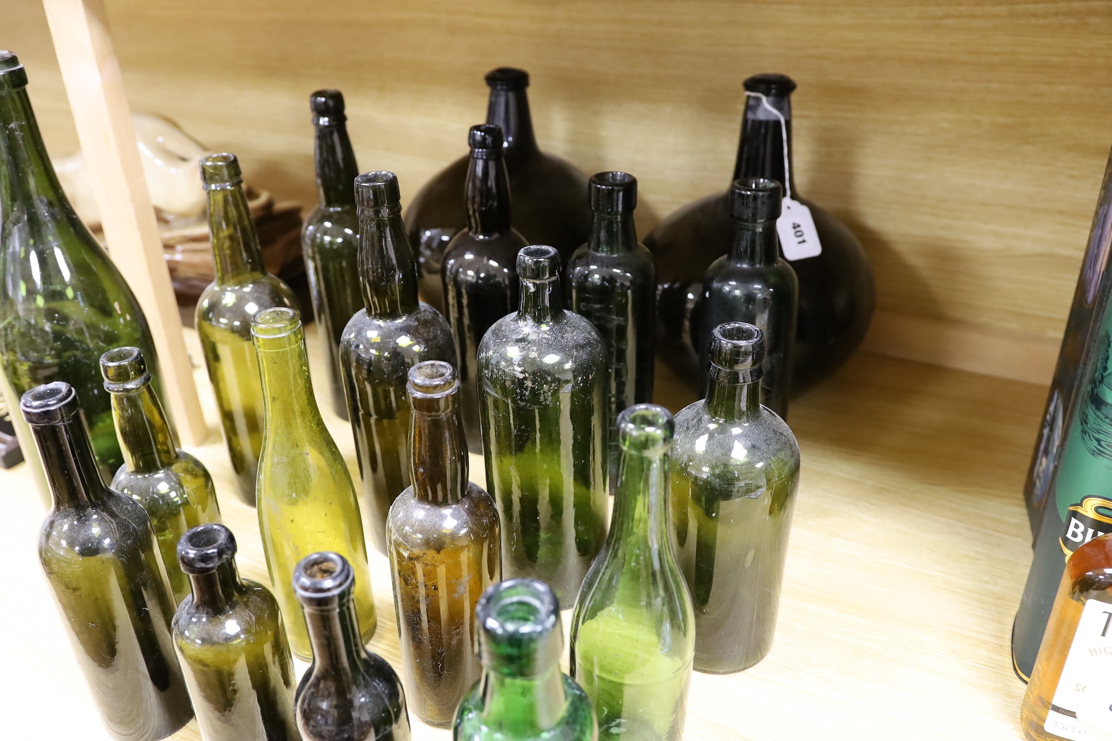 A pair of 18th century green glass onion bottles and a large quantity of other green glass bottles, tallest 38cm